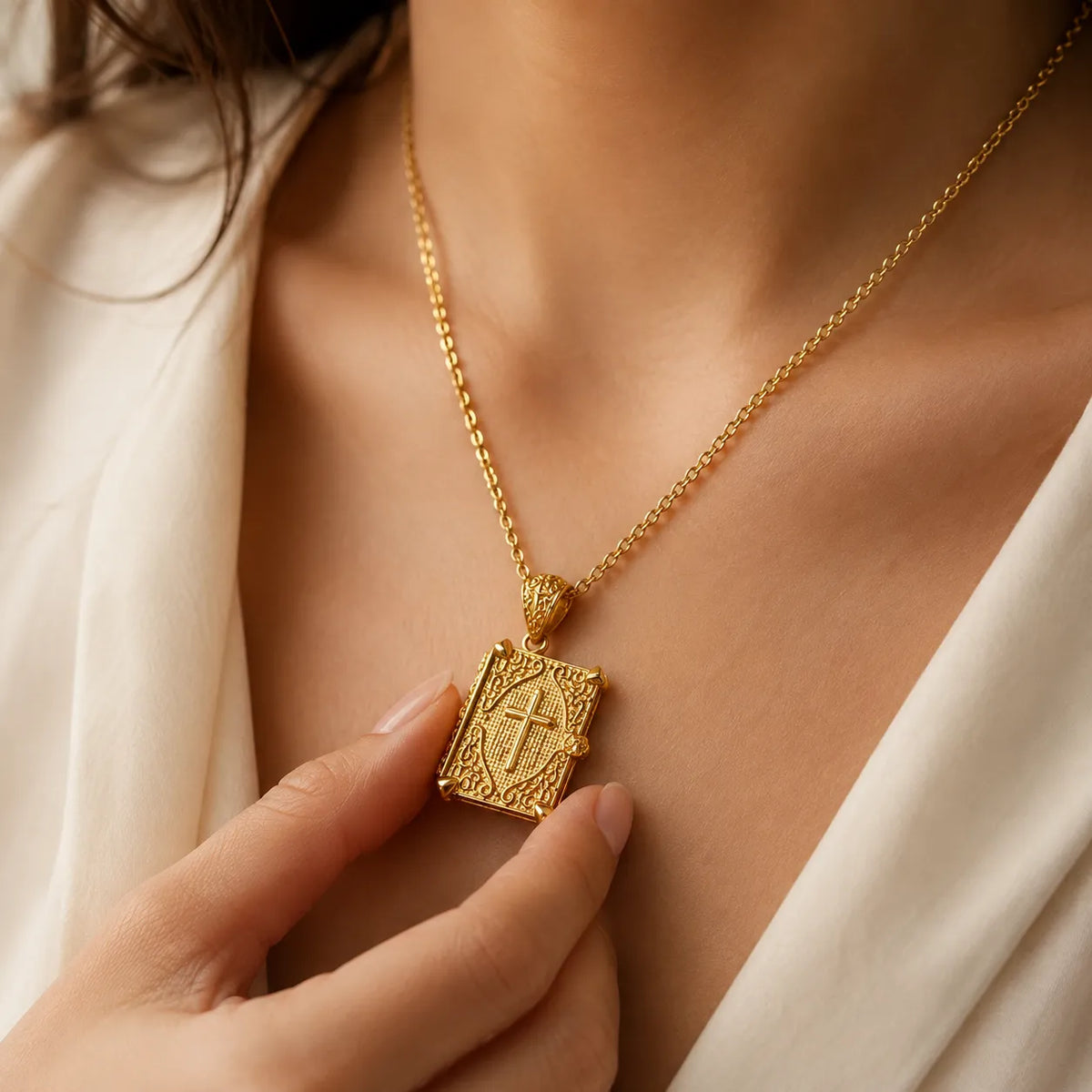 Gold Bible pendant detail with a cross